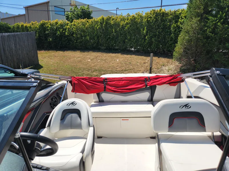 Slide: The Image of 2014 Monterey 234 SS boat interior with white seating and red cover. - 13