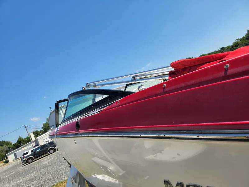 Slide: The Image of 2014 Monterey 234 SS boat with red and white exterior, parked outdoors. - 8