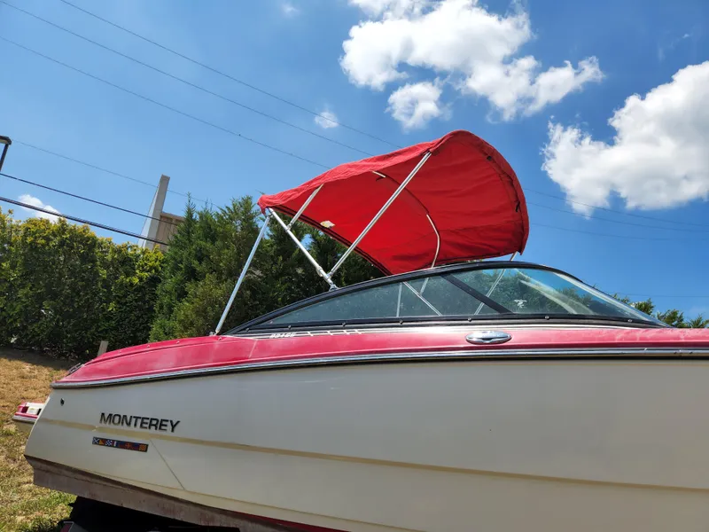Slide: The Image of 2014 Monterey 234 SS boat with red canopy under blue sky. - 2