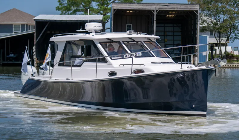 Slide: The Image of 2023 True North 34 OE boat cruising near docks, featuring sleek design and modern equipment. - 1