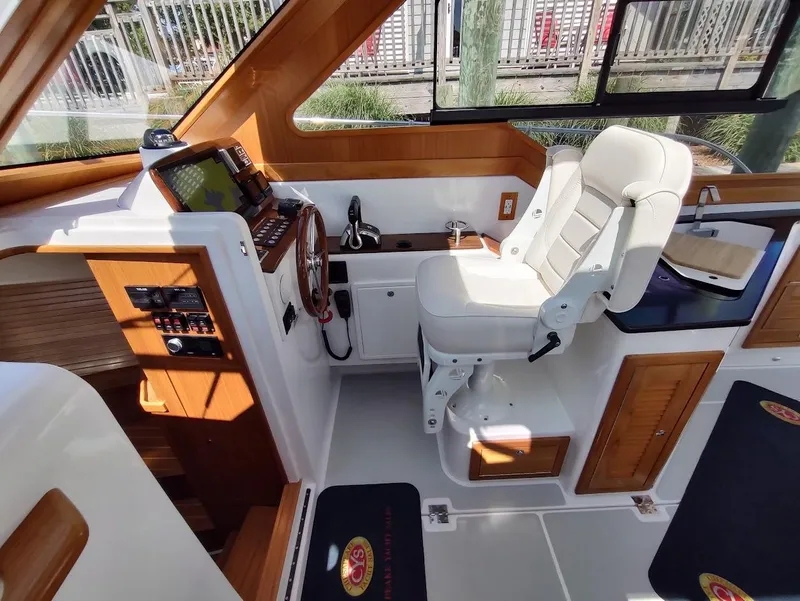 Slide: The Image of 2023 True North 34 OE boat interior with helm station and white captain's chair. - 11