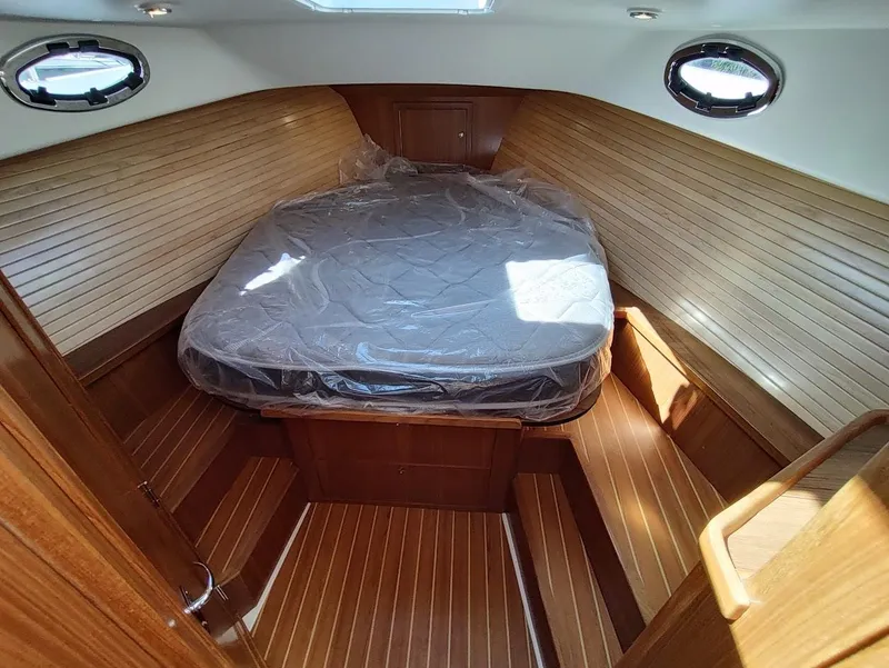 Slide: The Image of 2023 True North 34 OE cabin with wooden interior and bed. - 16