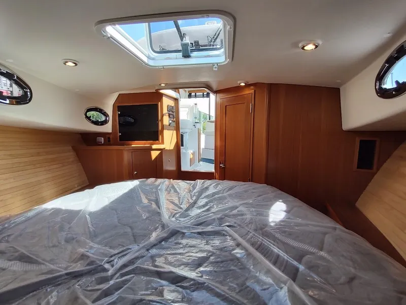 Slide: The Image of Interior of 2023 True North 34 OE yacht cabin with wood paneling and skylight. - 17