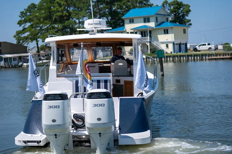 Slide: The Image of 2023 True North 34 OE boat with dual 300 engines on a calm waterway. - 2