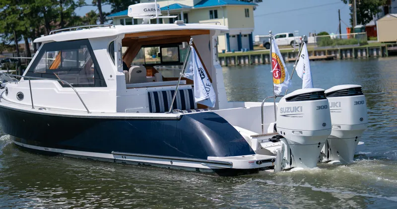 Slide: The Image of 2023 True North 34 OE boat with dual Suzuki engines on a calm waterway. - 4