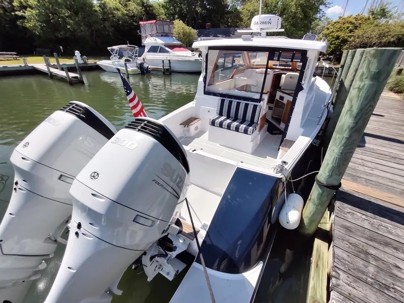 Slide: The Image of 2023 True North 34 OE boat docked with twin Suzuki outboard engines. - 8