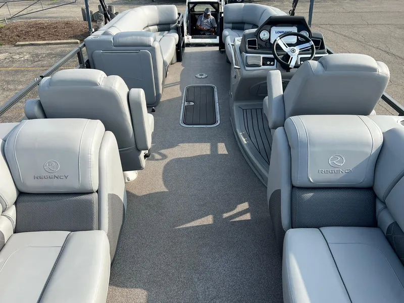 Slide: The Image of 2021 Regency 230 LE3 pontoon boat interior with luxurious seating and modern dashboard. - 9