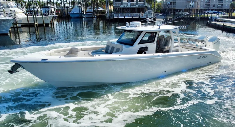 Slide: The Image of 2023 Solace 41 CS boat cruising in a marina with other boats docked. - 1