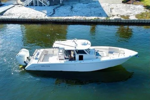 Slide: The Image of 2023 Solace 41 CS boat cruising on calm waters near a dock. - 10