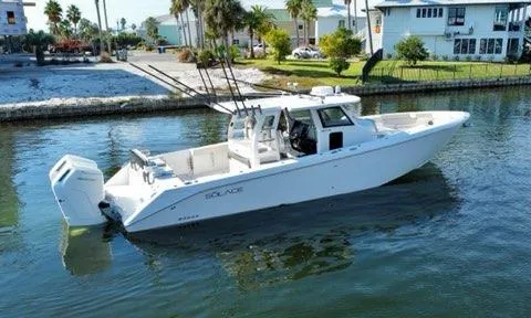 Slide: The Image of 2023 Solace 41 CS boat cruising on a calm waterway near a residential area. - 12