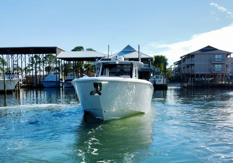 Slide: The Image of 2023 Solace 41 CS boat cruising in a marina with waterfront homes. - 14