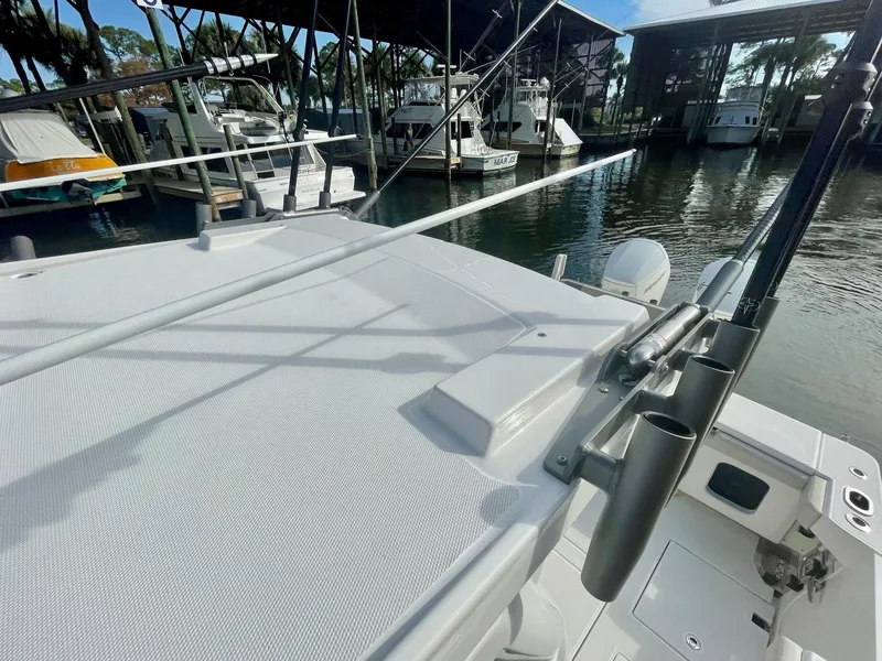 Slide: The Image of 2023 Solace 41 CS boat docked at a marina with fishing rod holders. - 24