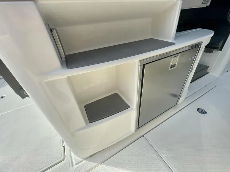 Slide: The Image of 2023 Solace 41 CS boat interior with storage compartments and stainless steel refrigerator. - 32