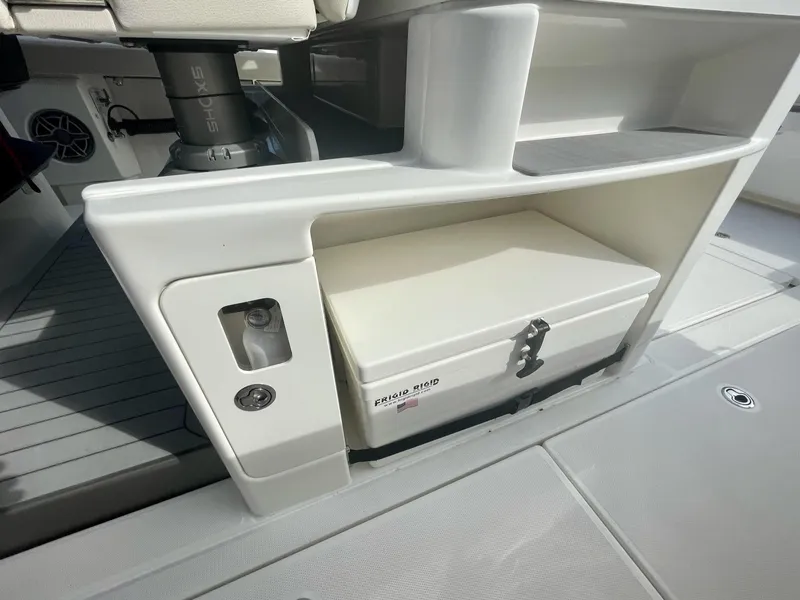 Slide: The Image of 2023 Solace 41 CS boat storage compartment with a white tackle box. - 34