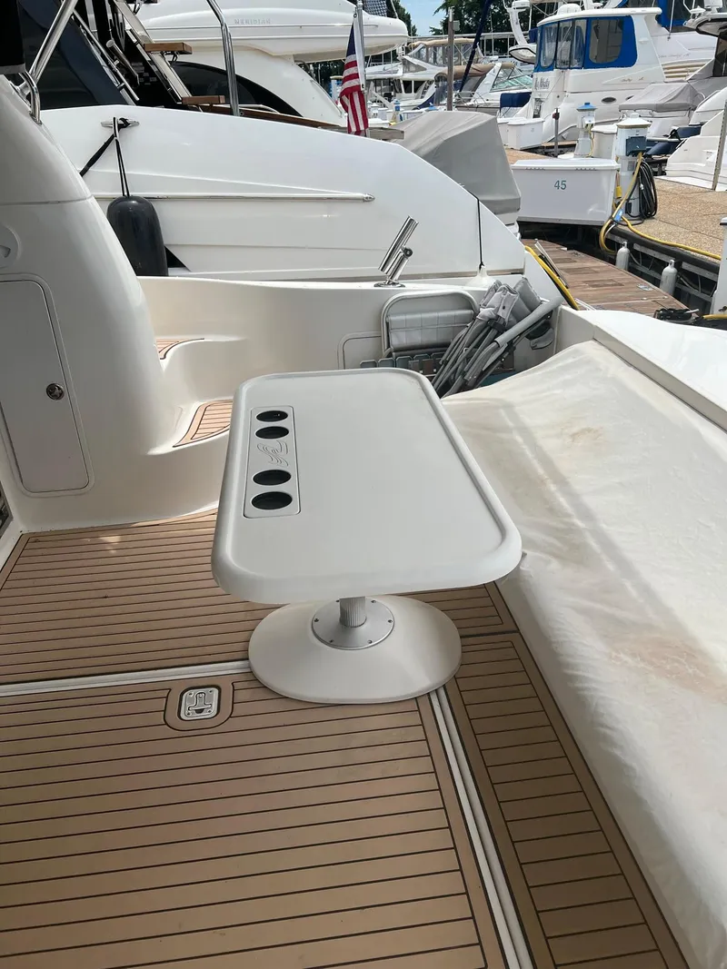 Slide: The Image of 2003 Sea Ray 480 Sedan Bridge yacht deck with white table and cup holders. - 11