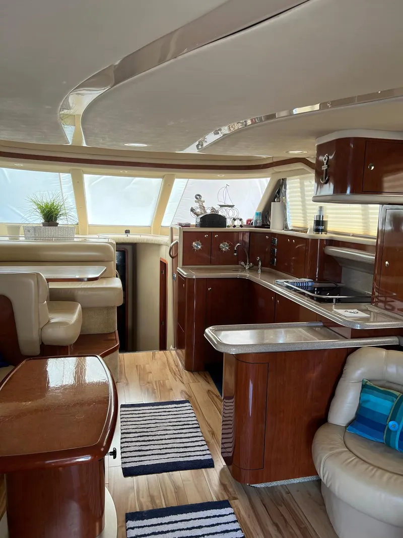Slide: The Image of Luxurious interior of 2003 Sea Ray 480 Sedan Bridge yacht with modern kitchen and seating area. - 14