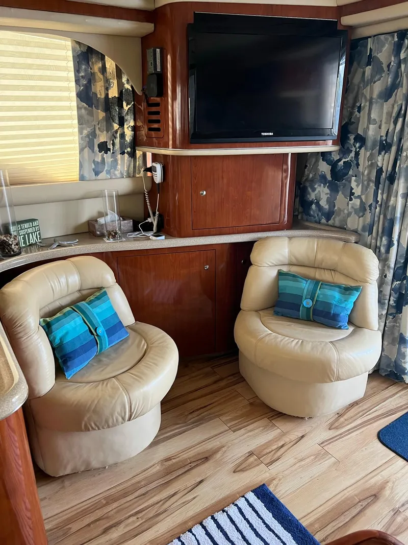 Slide: The Image of Interior of 2003 Sea Ray 480 Sedan Bridge with leather chairs and TV. - 18