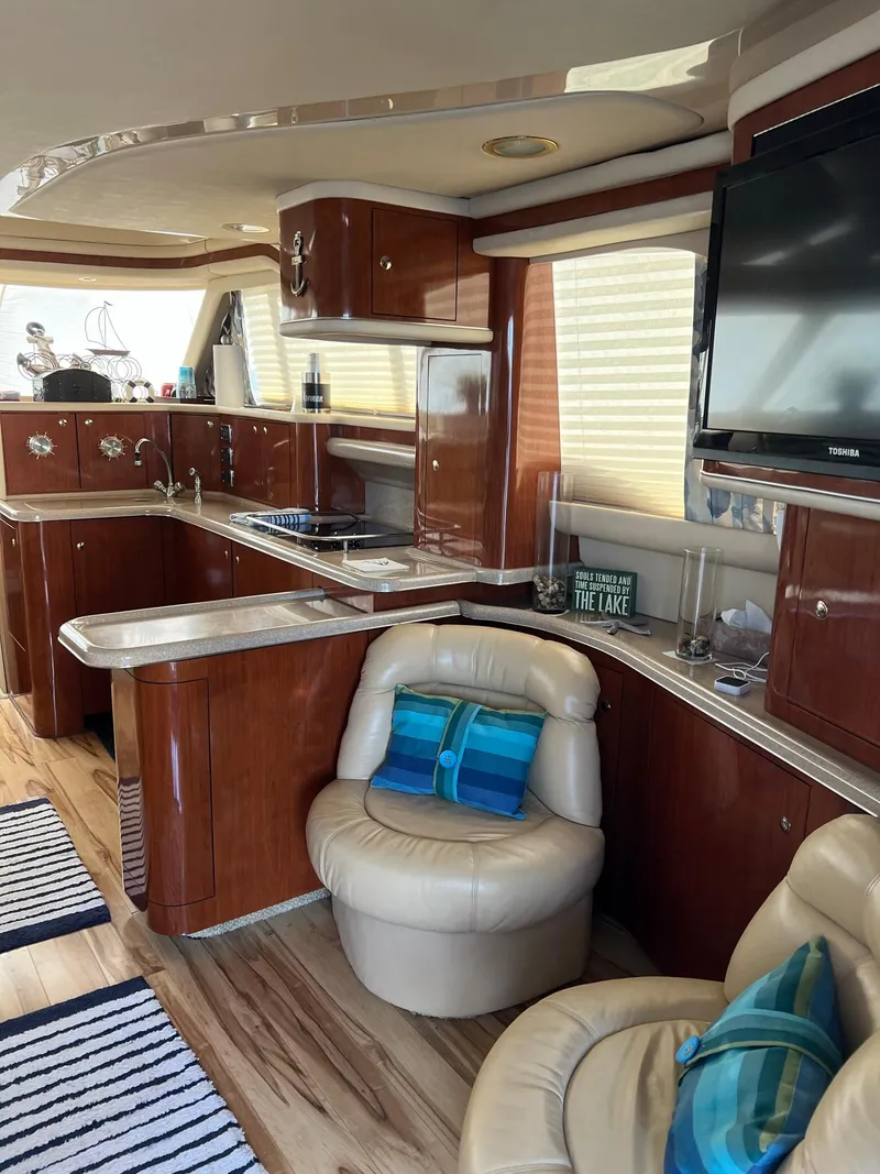 Slide: The Image of Luxurious interior of 2003 Sea Ray 480 Sedan Bridge yacht with modern kitchen and seating. - 20