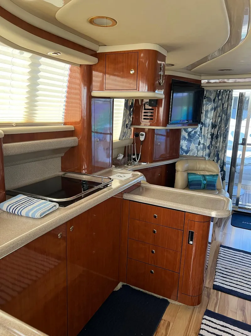 Slide: The Image of Interior of 2003 Sea Ray 480 Sedan Bridge yacht with modern kitchen and seating area. - 23