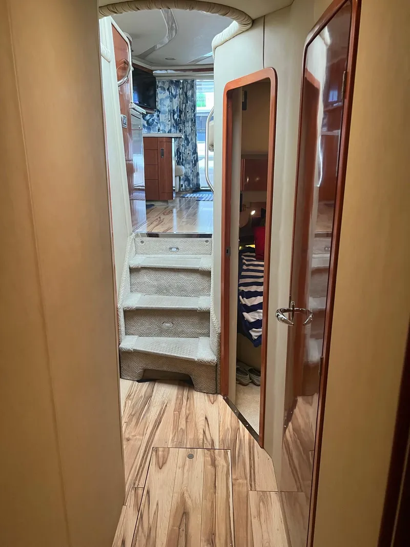 Slide: The Image of Interior view of 2003 Sea Ray 480 Sedan Bridge yacht with wooden flooring and stairs. - 28