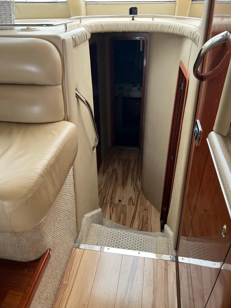 Slide: The Image of Interior view of 2003 Sea Ray 480 Sedan Bridge yacht, featuring a cozy stairway and elegant wood finishes. - 29