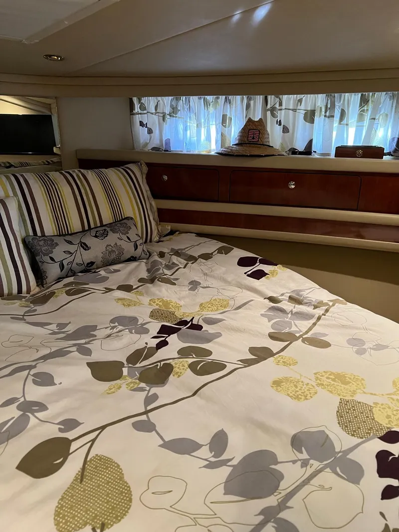 Slide: The Image of Cozy bedroom interior of 2003 Sea Ray 480 Sedan Bridge with floral bedding and striped pillows. - 33