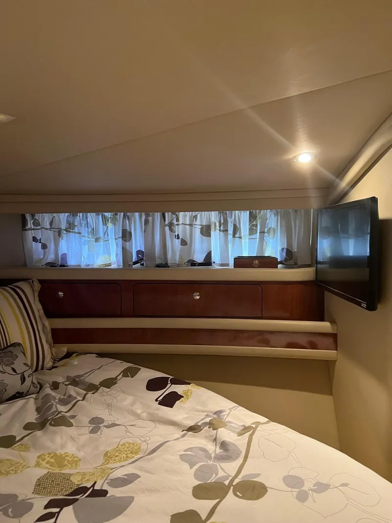 Slide: The Image of Cozy bedroom interior of 2003 Sea Ray 480 Sedan Bridge with TV and floral bedding. - 34