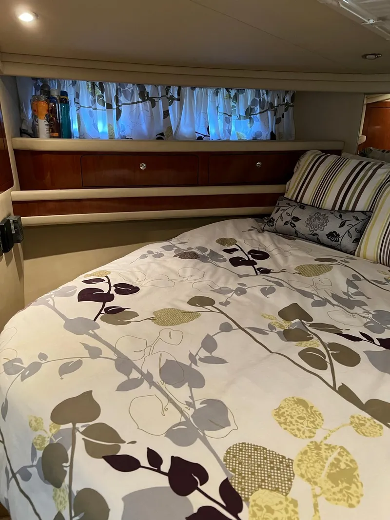 Slide: The Image of Cozy bedroom interior of 2003 Sea Ray 480 Sedan Bridge with floral bedding and striped pillows. - 36