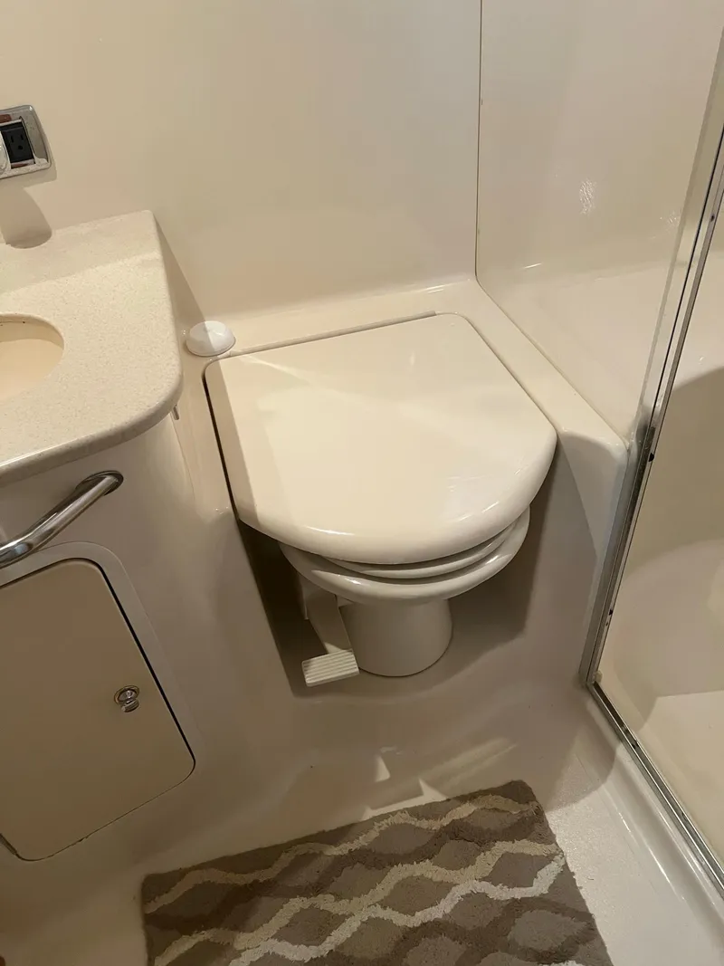 Slide: The Image of Bathroom interior of 2003 Sea Ray 480 Sedan Bridge yacht, featuring a compact toilet. - 43