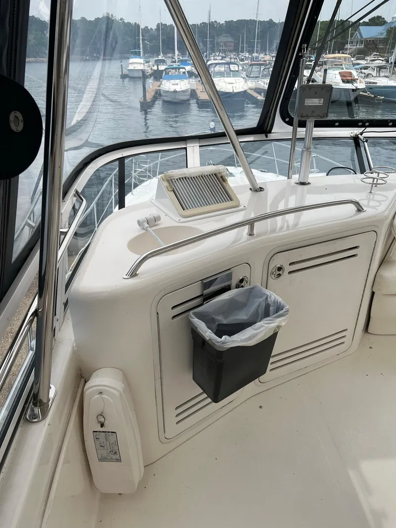 Slide: The Image of 2003 Sea Ray 480 Sedan Bridge helm with marina view in the background. - 48