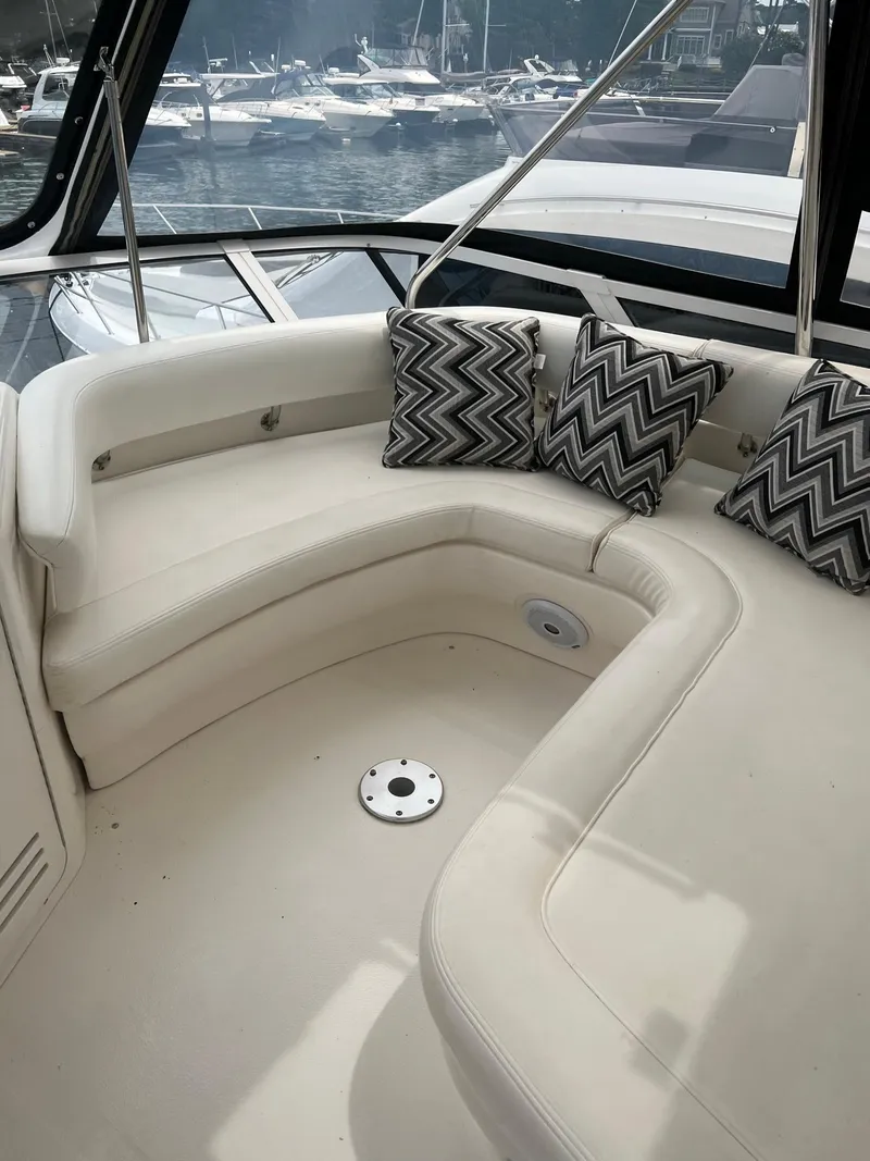 Slide: The Image of 2003 Sea Ray 480 Sedan Bridge yacht with cushioned seating and patterned pillows. - 49