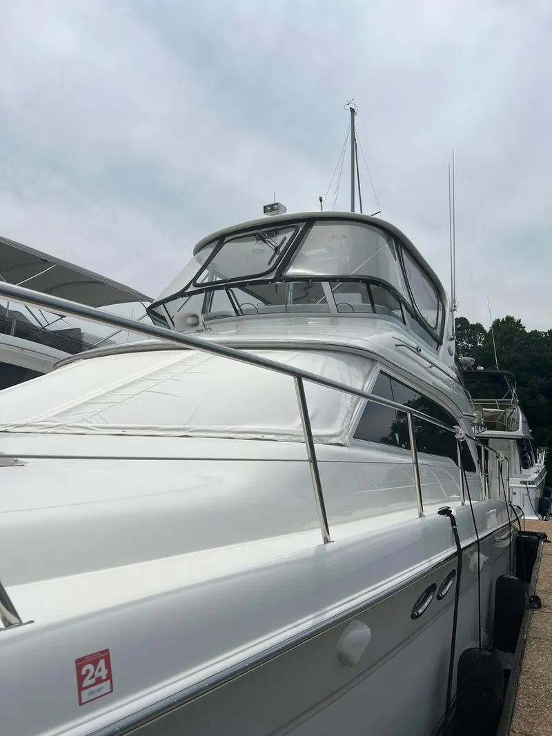 Slide: The Image of 2003 Sea Ray 480 Sedan Bridge yacht docked, showcasing sleek design and spacious flybridge. - 5
