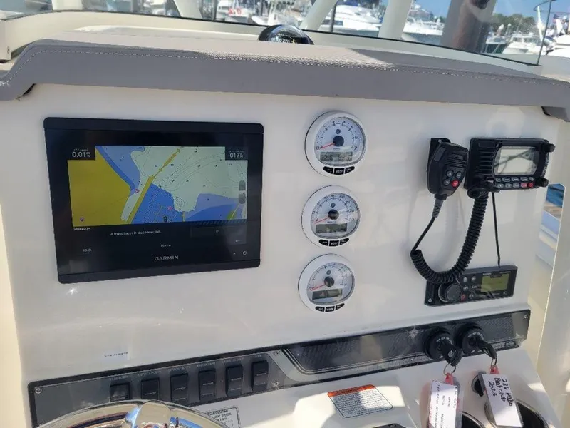 Slide: The Image of Mako 236 CC DUAL 2020 boat dashboard with GPS, gauges, and communication devices. - 12