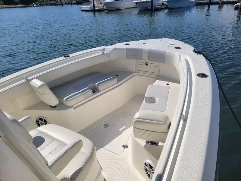 Slide: The Image of 2020 Mako 236 CC Dual boat interior with seating, docked on calm water. - 5