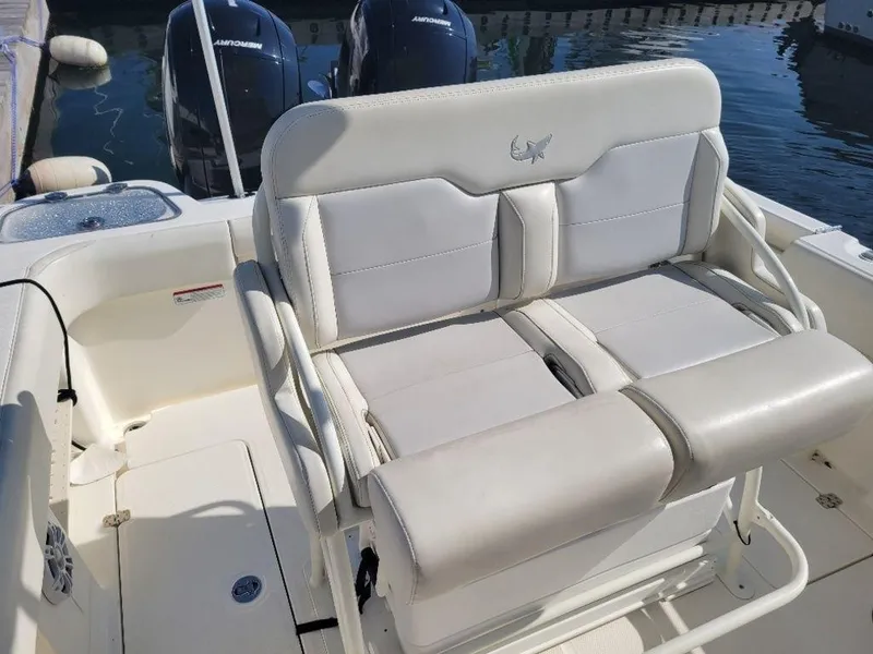 Slide: The Image of 2020 Mako 236 CC Dual boat with white seating and twin outboard motors. - 7