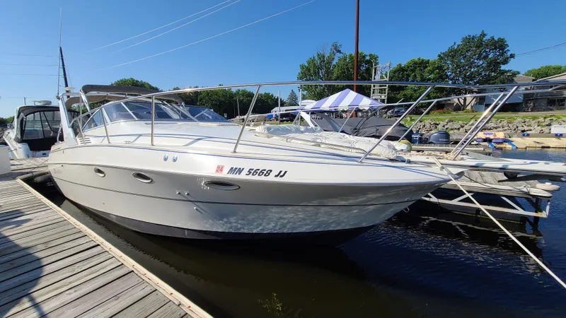 The Image of 1994 Larson 300 Cabrio boat docked at a marina on a sunny day. - 0