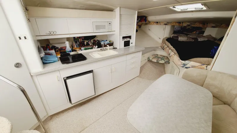 Slide: The Image of Interior of 1994 Larson 300 Cabrio boat with kitchenette and seating area. - 19