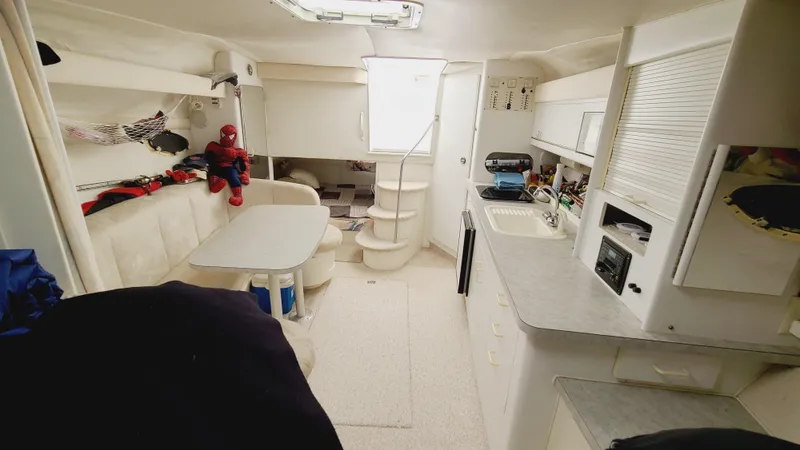 Slide: The Image of 1994 Larson 300 Cabrio boat interior with kitchen, dining area, and stairs. - 21