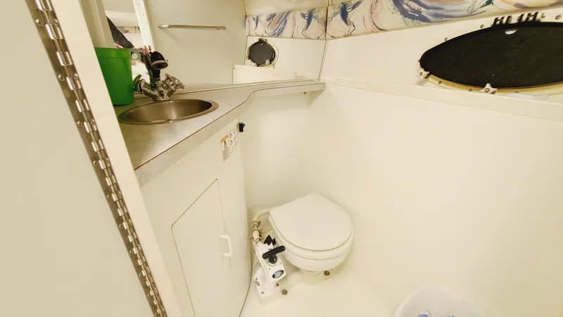 Slide: The Image of 1994 Larson 300 Cabrio boat bathroom with sink and toilet. - 25