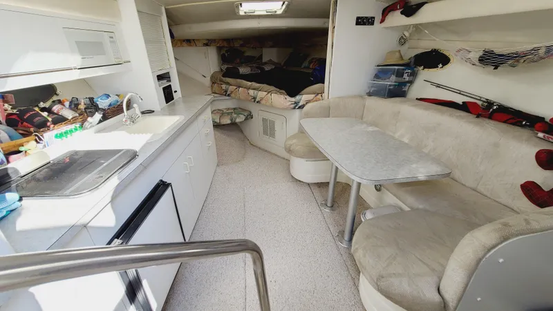 Slide: The Image of 1994 Larson 300 Cabrio interior with kitchen, dining area, and sleeping quarters. - 16