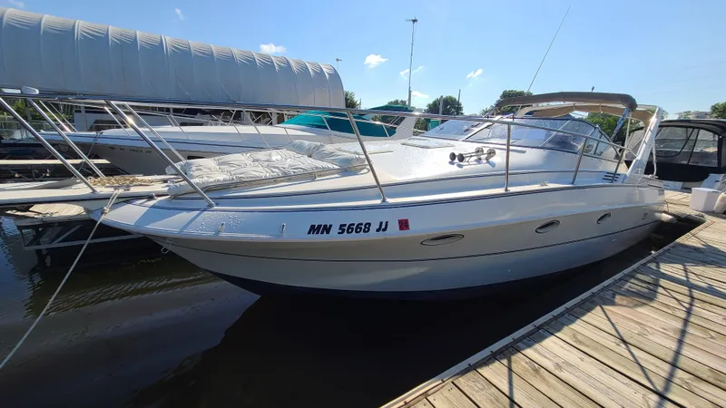 Slide: The Image of 1994 Larson 300 Cabrio boat docked at a marina on a sunny day. - 2