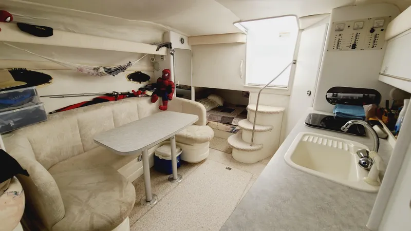 Slide: The Image of 1994 Larson 300 Cabrio interior with dining area, kitchen, and stairs to cabin. - 22