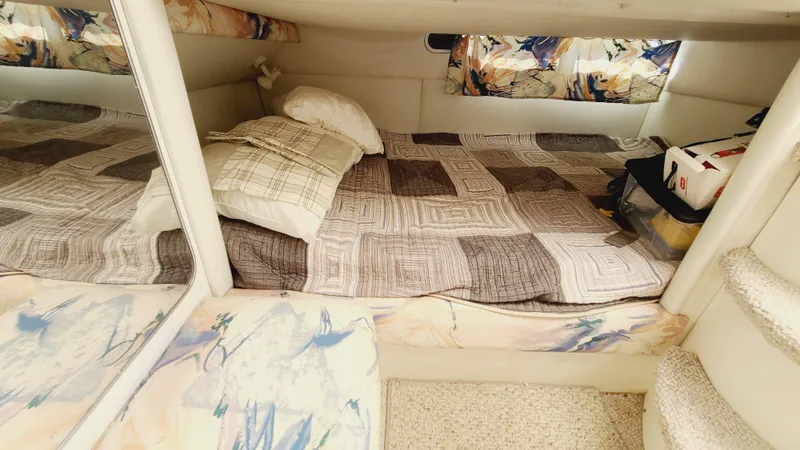 Slide: The Image of 1994 Larson 300 Cabrio cabin interior with bed and storage. - 24