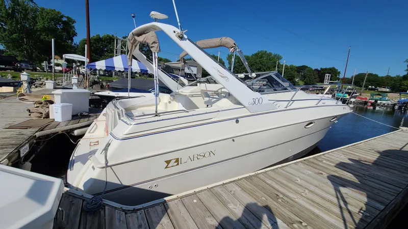 Slide: The Image of 1994 Larson 300 Cabrio boat docked at a marina on a sunny day. - 3