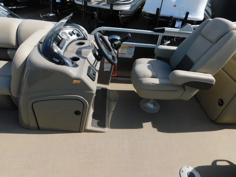 Slide: The Image of 2023 Sun Tracker Party Barge 22 RF DLX boat interior with captain's chair and control console. - 13