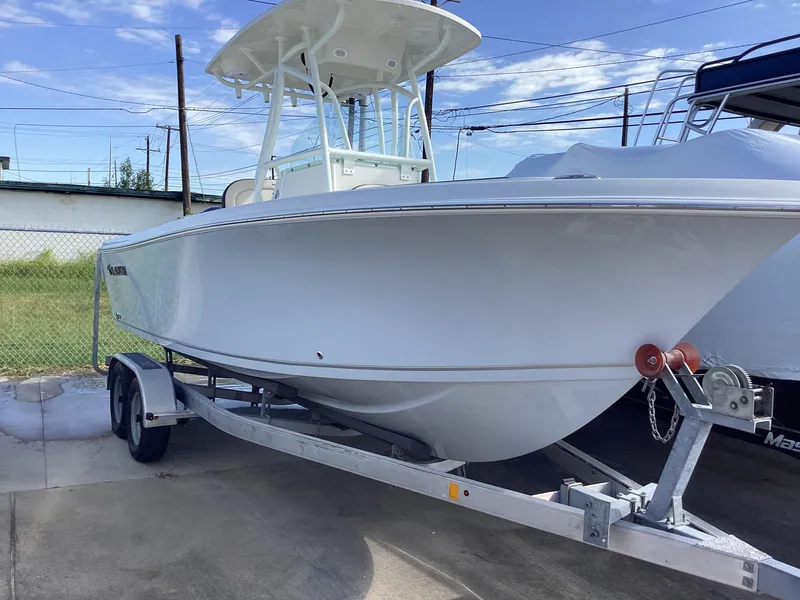 The Image of 2022 Sailfish 220 CC boat on trailer, parked outdoors under blue sky. - 0
