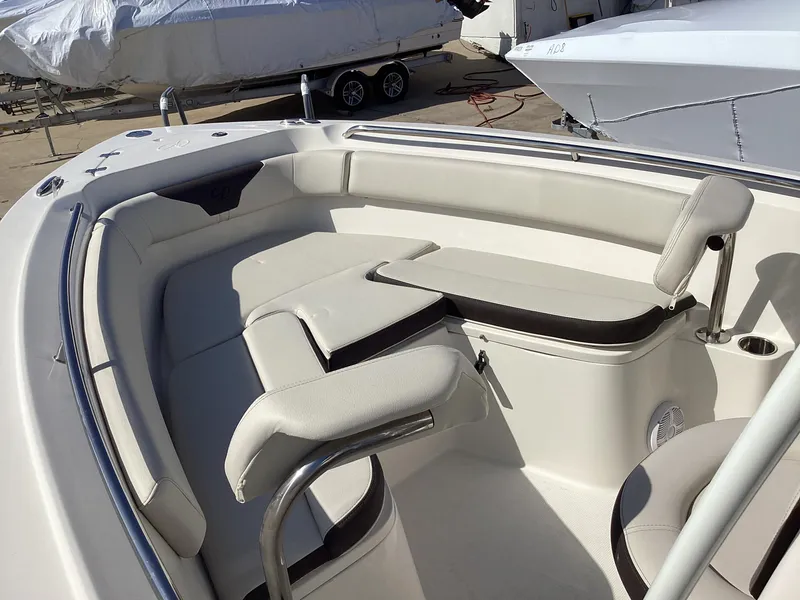 Slide: The Image of 2022 Sailfish 220 CC boat interior with cushioned seating and stainless steel railings. - 14