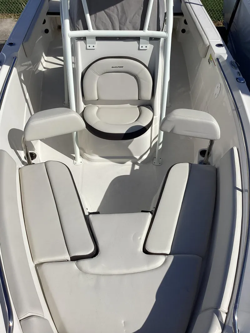 Slide: The Image of 2022 Sailfish 220 CC boat interior with cushioned seating and white upholstery. - 18