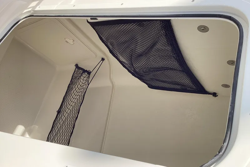 Slide: The Image of 2022 Sailfish 220 CC storage compartment with netting for secure storage. - 19
