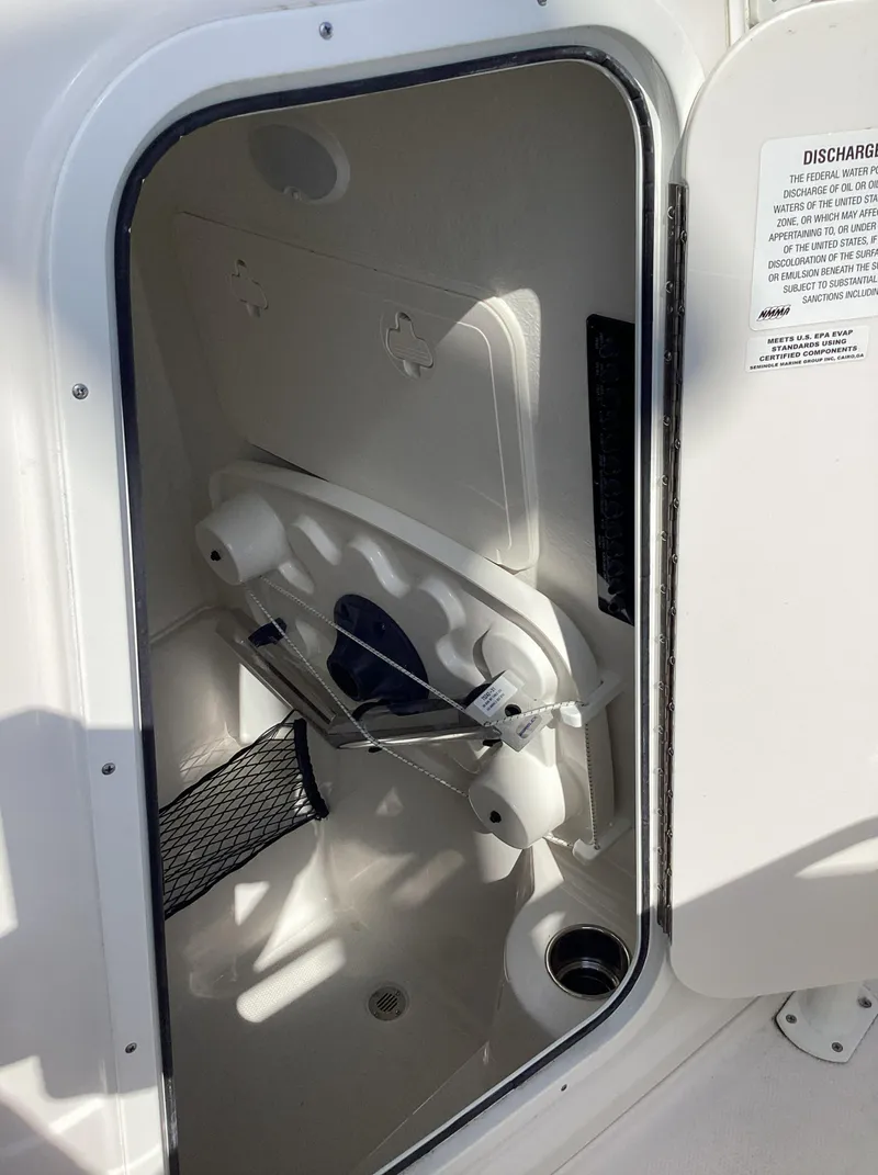 Slide: The Image of 2022 Sailfish 220 CC storage compartment with open door, showcasing interior space. - 20